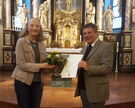 Organistin Dorothea Holzhausen wird von Pfarrer Matthias Kaminski für ihre 30-jährige Tätigkeit geehrt.